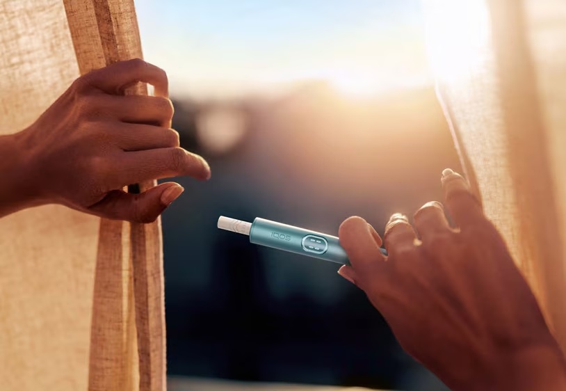 Philip Morris International product being used beside an open curtain